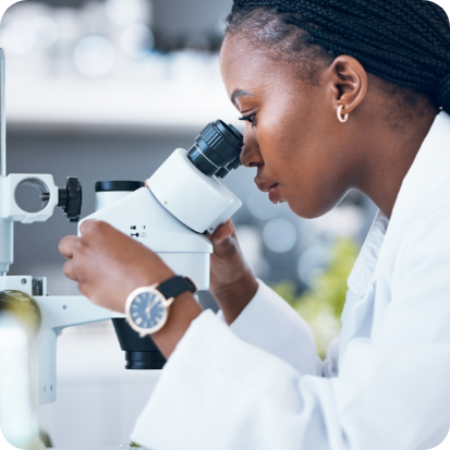 A woman looking into a microscope