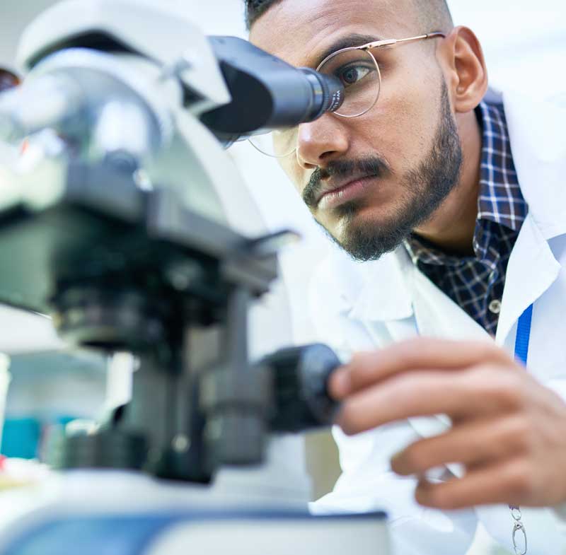 man studying microscope